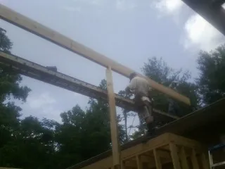Carpenter setting a ridge beam over a new addition frame — Ice Dam Removal by Roofing Brothers in North Freedom