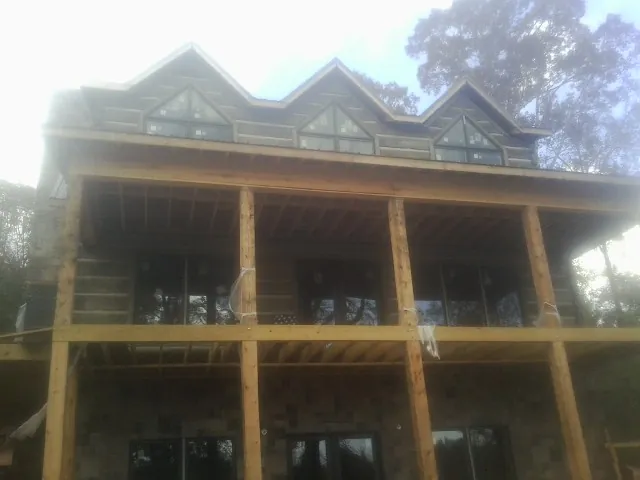 Dormers and porch framing on a large log home under construction — Roof Coating work by our crew in North Freedom