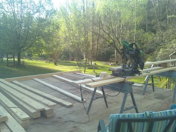Miter saw and framing lumber on a deck under construction in North Freedom