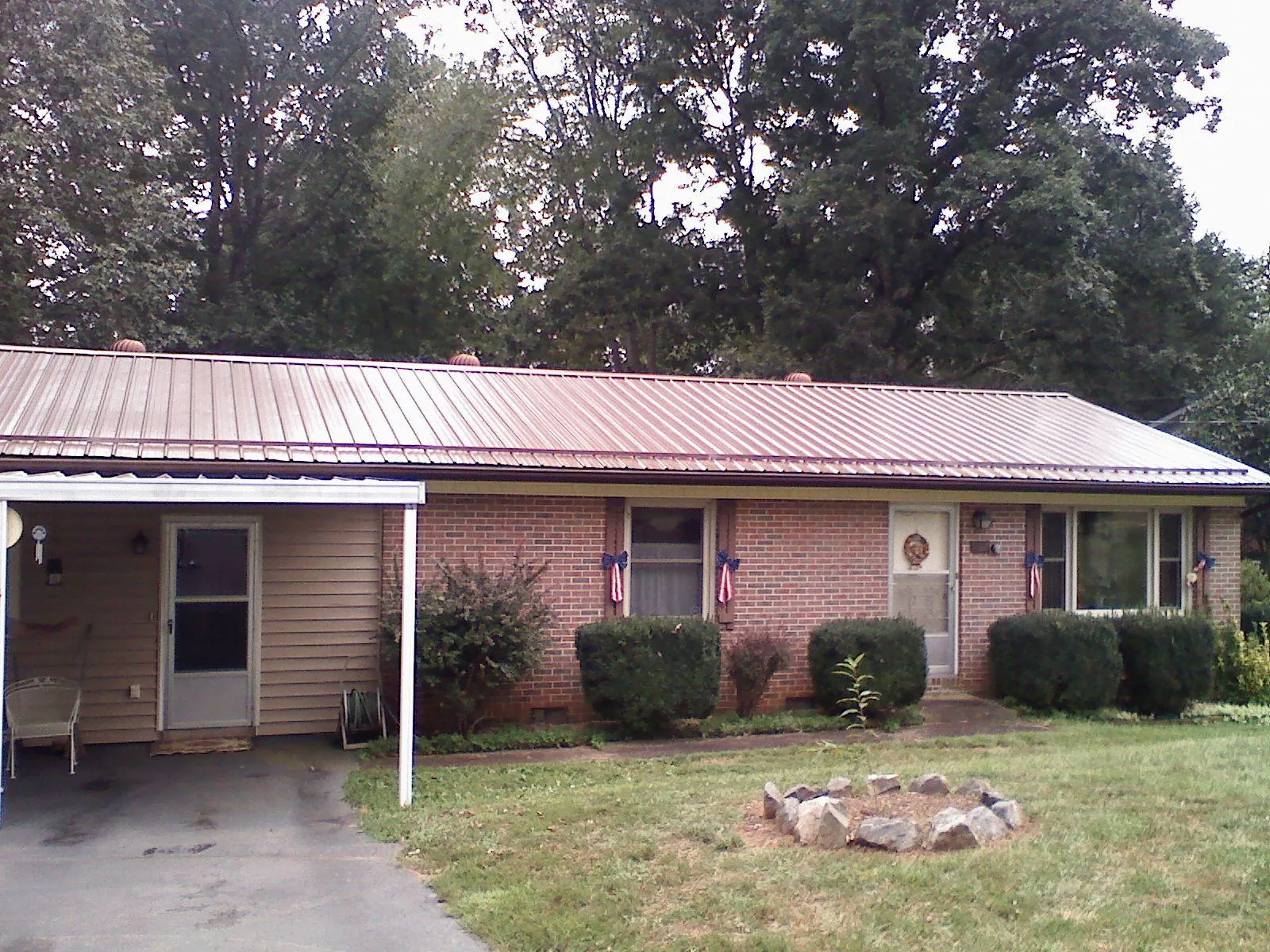 Bronze metal roof and carport on a brick ranch home — Roof Repair work by our crew in North Freedom