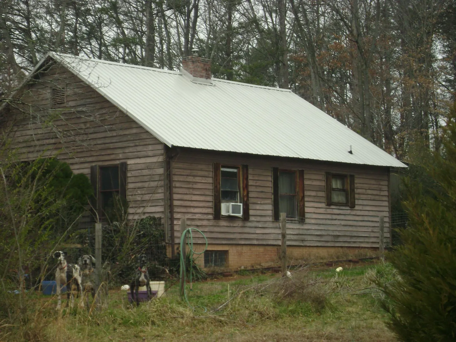 White metal roof on an old wood sided farmhouse, from a Metal Roof Installation job in North Freedom